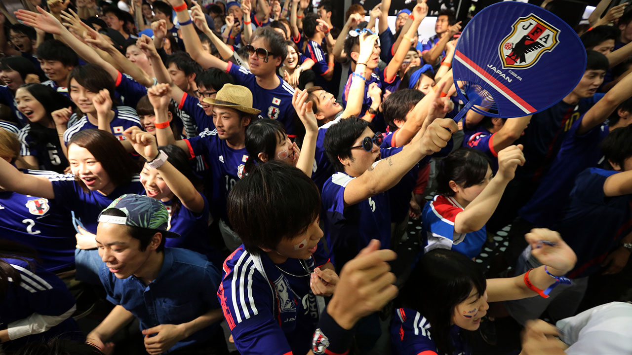 Japanese soccer fans support their team during a live broadcast of the group C World Cup soccer match against Ivory Coast.