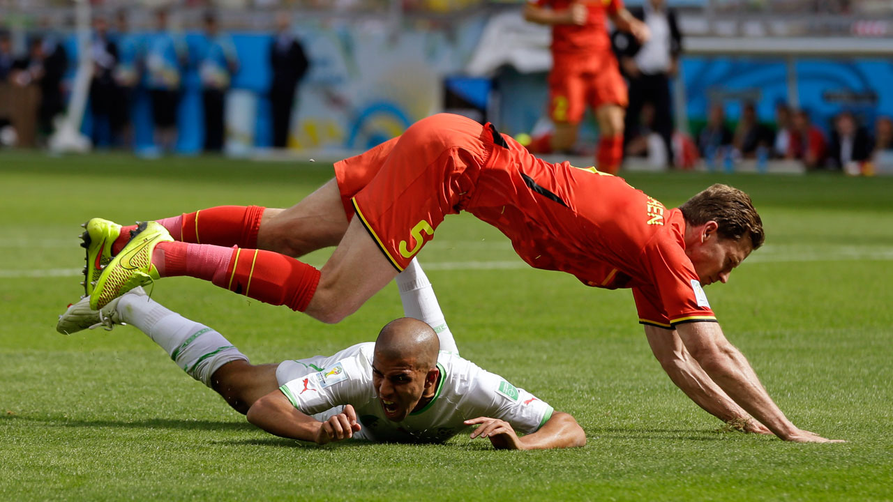 Algeria's Sofiane Feghouli is brought down by Belgium's Jan Vertonghen. Feghouli scored on a penalty kick to give Algeria a 1-0 lead.
